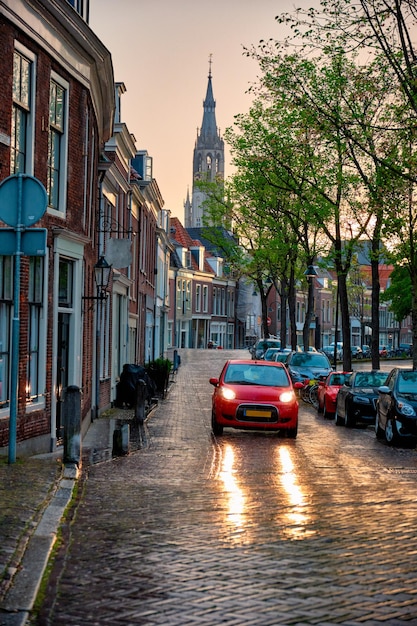 Photo rue pavée de delft avec voiture sous la pluie