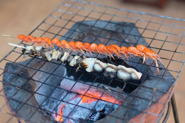 Rue piétonne de Chiang Khan : cuisine locale, crevettes râpées, moules de riz, brochettes, grillées sur la cuisinière.