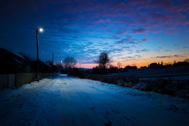 Photo rue rurale le soir au coucher du soleil avec la lumière des lanternes_