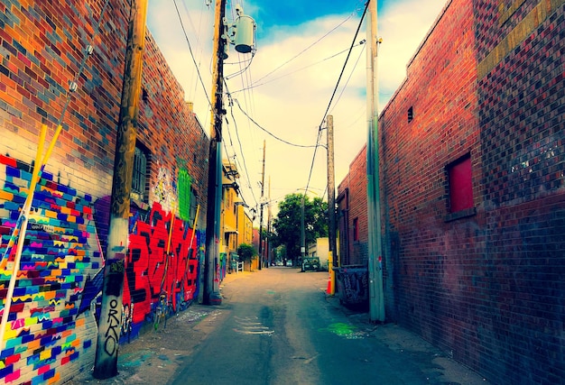 Photo une ruelle couverte de graffitis avec un panneau rouge et bleu qui dit 