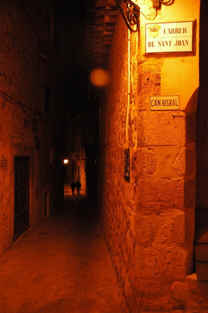 Photo une ruelle étroite au milieu de vieux bâtiments dans la ville la nuit