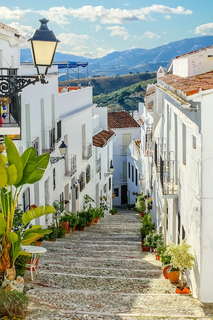 Ruelle étroite d'une ville andalouse et les montagnes en arrière-plan. Frigiliana