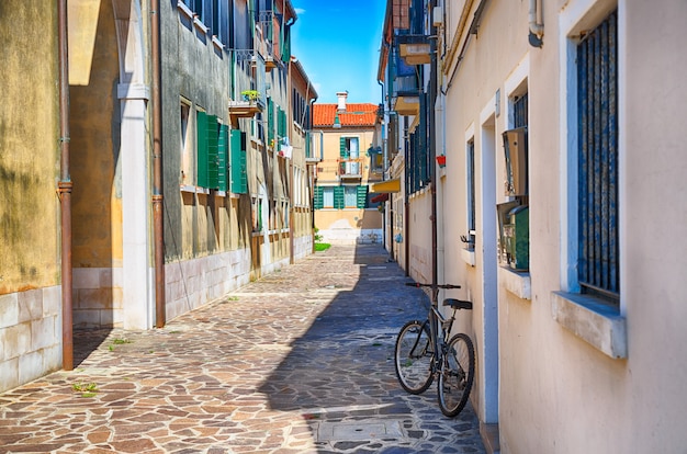 Ruelle avec un vélo le matin dans l'île de Murano, Venise, Italie