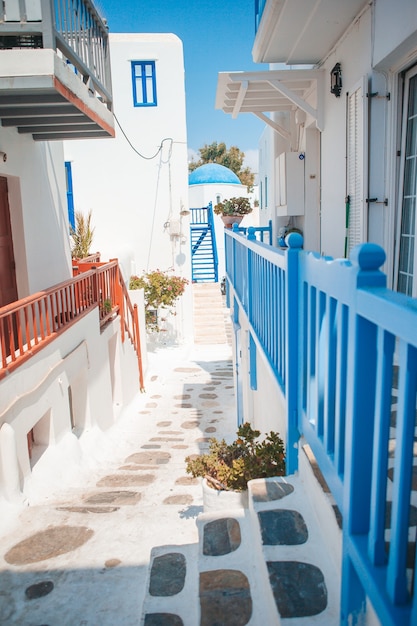Les rues étroites de l'île avec des balcons bleus, des escaliers et des fleurs en Grèce.
