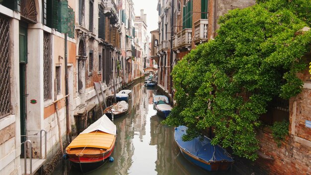 Rues étroites de Venise avec canal rempli d'eau bateaux amarrés