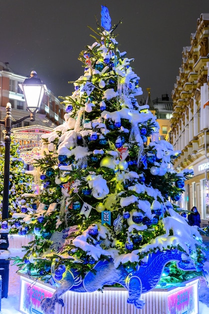 Les rues de la ville décorées d'arbres de Noël et de guirlandes pendant la Saint-Sylvestre La tempête de neige