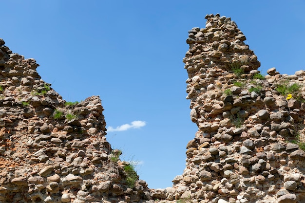 Ruiné et envahi par les ruines d'herbe d'une ancienne forteresse et de pierres et de briques, ruines de structures défensives du Moyen Âge