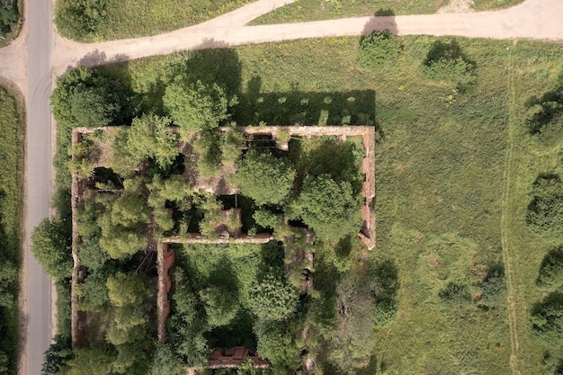 Ruines d'une ancienne caserne de l'armée uniquement des murs de briques rouges sans toit recouvert d'herbe et d'arbres