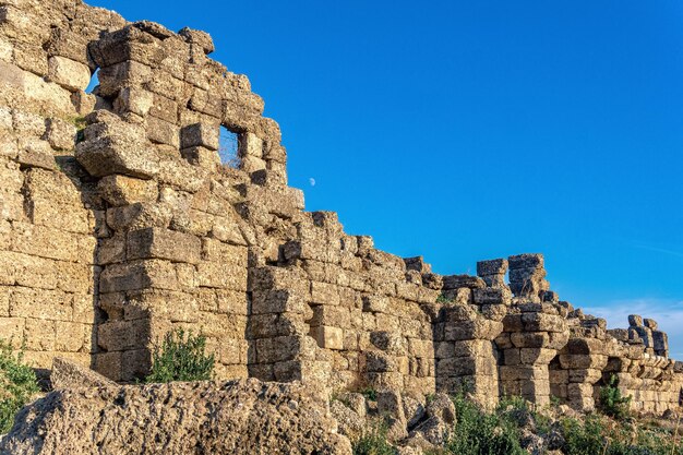 Ruines des anciens remparts de la ville sur fond de lune à Side, Turquie