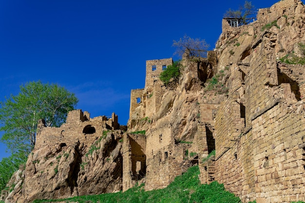 Ruines des murs des maisons sur une falaise dans le village abandonné de Gamsutl