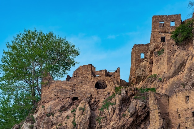 Ruines des murs des maisons sur une falaise dans le village abandonné de Gamsutl