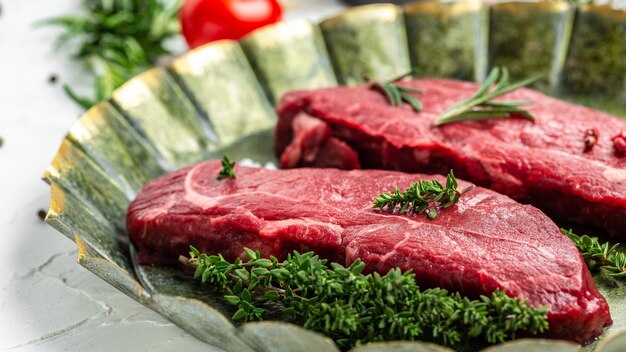 Rump steak aux épices servi sur un vieux plateau de viande sur fond clair. Vue de dessus.