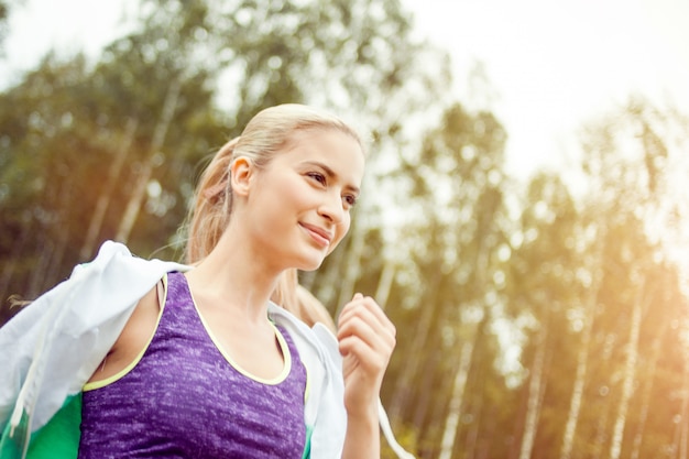 Runner fille heureuse et en bonne santé sur la route, jogging matinal