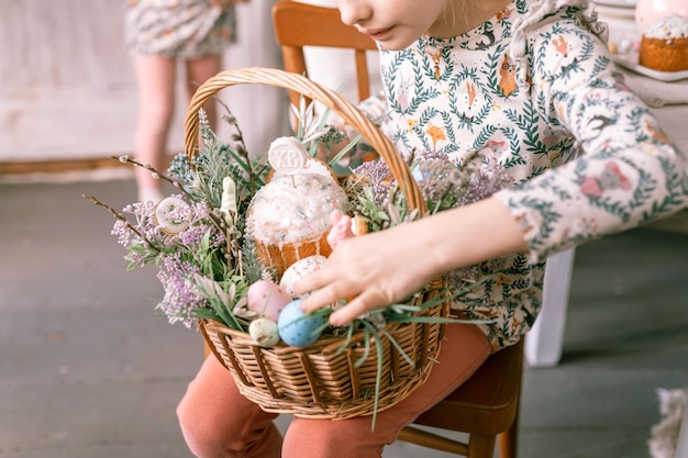 Russie Moscou 04092022 joyeuses fêtes de pâques au printemps petite fille de huit ans tient un panier avec des oeufs peints et des gâteaux de pâques festifs décoration de la maison cuisine traditionnelle