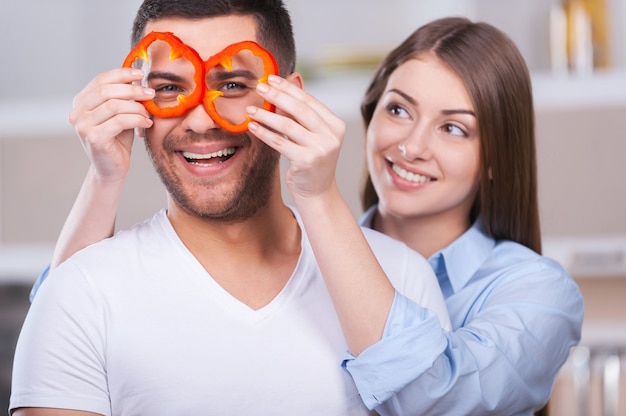 S'amuser dans la cuisine. Beau jeune couple s'amusant dans la cuisine