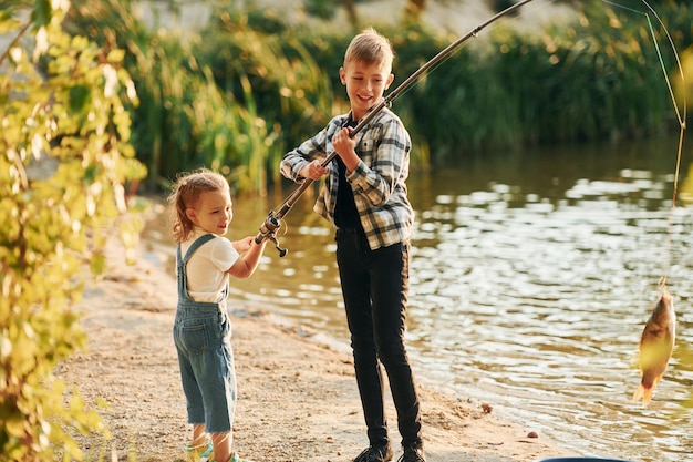 S'amuser Garçon avec sa sœur dans la pêche à l'extérieur en été ensemble