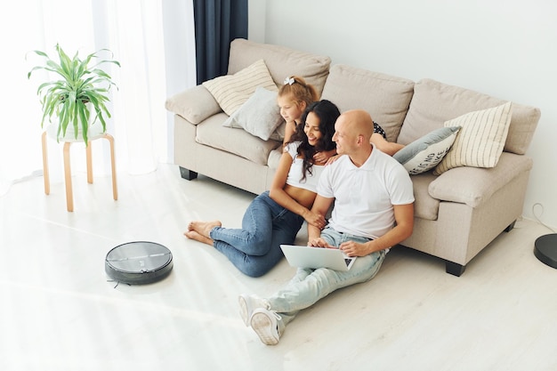 S'appuyant sur le canapé, un couple joyeux est ensemble à l'intérieur