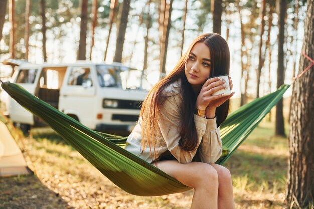 S'assoit sur le hamac La femme voyage seule dans la forêt pendant la journée en été