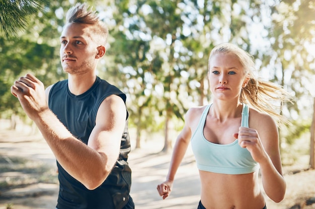 S'engager à être en forme Photo d'un jeune couple courant ensemble à l'extérieur