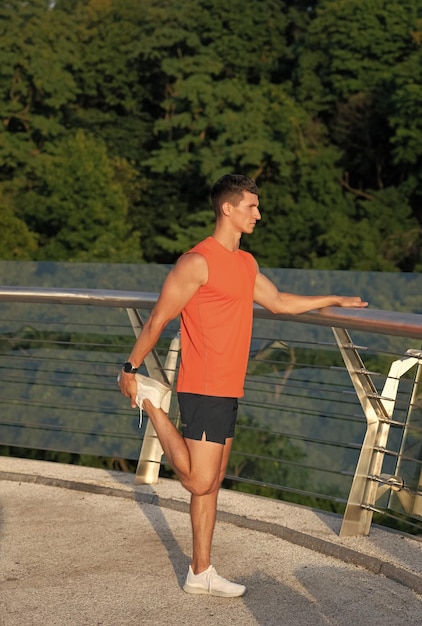 S'étirer après l'entraînement Sportif attrape la cheville avec la main Étirement quadruple debout Routine d'étirement