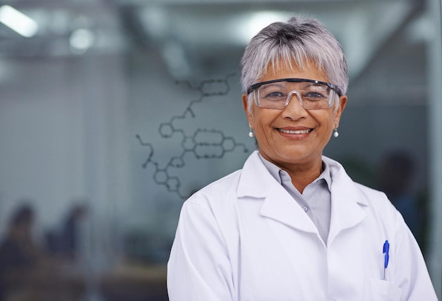 Sa découverte va changer des vies Une femme scientifique debout devant un tableau en verre avec une formule dessus