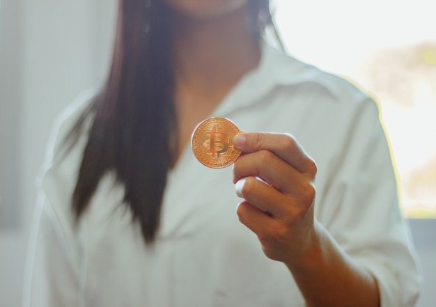 Sa main tient bitcoin l&#39;argent futur dans la main de femme. pour l&#39;avenir et l&#39;ère nouvelle de l&#39;argent.