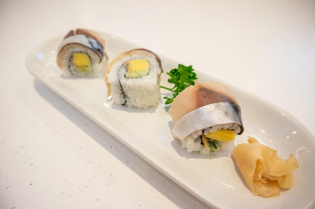 Saba sushi roll sur plaque blanche