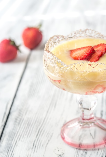 Photo sabayon aux tranches de fraise sur le fond en bois