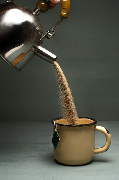 Photo le sable coule d'une théière dans une tasse.