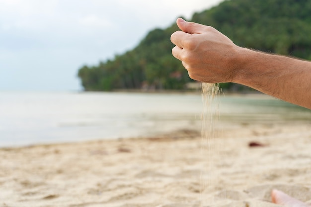 Photo le sable est versé d'une main