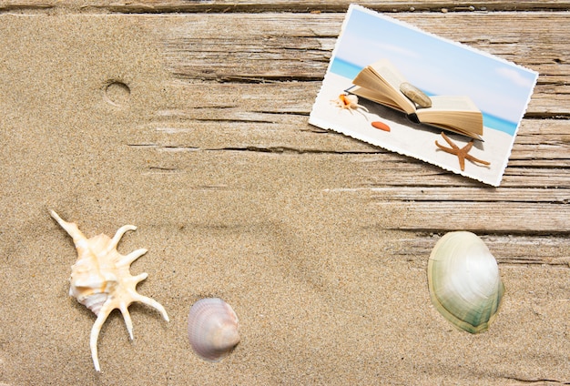 Sable et livre sur planches de bois, fond d&#39;été avec espace de copie