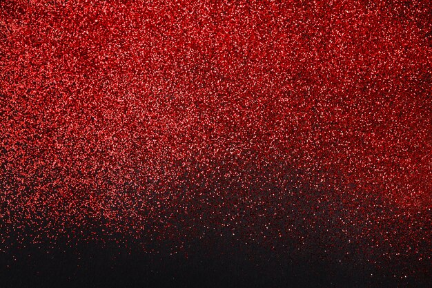 Sable de paillettes rouge isolé sur fond noir