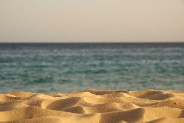 Sable sur une plage de l'océan atlantique avec une eau floue en arrière-plan