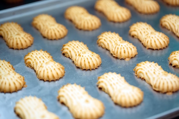 Photo sables. production de biscuits sablés dans une usine de confiserie. biscuits sablés sur une grille en métal après la cuisson au four.