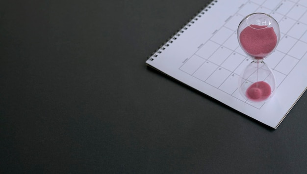 Sablier avec du sable qui coule sur le dessus du calendrier