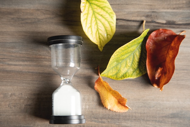 Sablier et feuilles sur la table