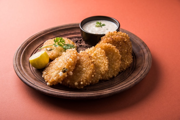 Sabudana ou Sago Vada est une collation traditionnelle frite d'Inde. Servi avec chutney épicé vert ou aux arachides. Servir dans une assiette en bois sur fond coloré ou en bois. Mise au point sélective