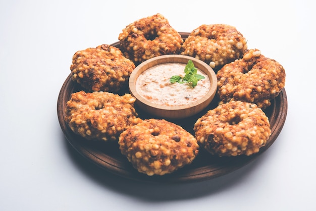 Sabudana vada ou gâteau frit au sagou servi avec un chutney d'arachide sur fond de mauvaise humeur, recette de jeûne populaire d'Inde.