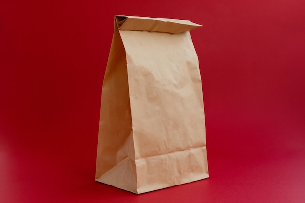 Sac artisanal en papier brun pour faire du shopping sur fond rouge