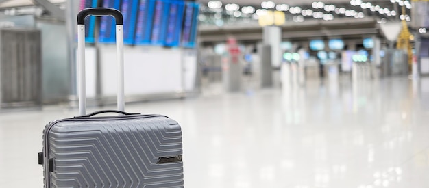 Sac à bagages dans la valise de chariot du terminal de l'aéroport international avec panneau d'information en arrière-plan de l'aérodrome Concepts de voyage et de vacances d'assurance transport