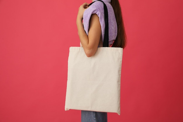 Un sac blanc dans les mains sur un fond rouge