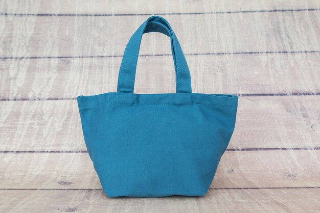 Sac bleu pour femmes sur une surface en bois.