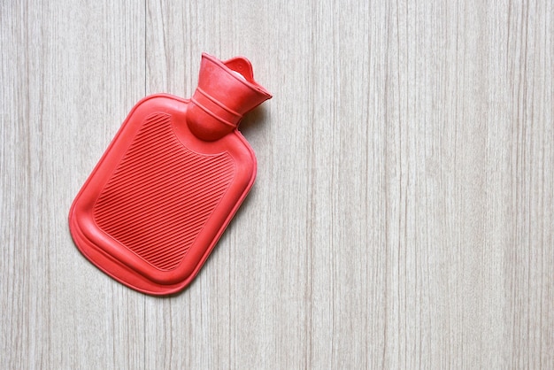 Sac de bouillotte rouge en caoutchouc sur table en bois