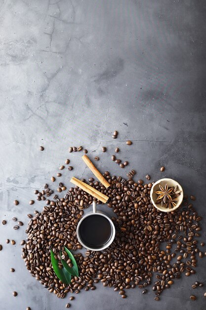 Sac de café. Grains de café torréfiés sur la table. Grains de café avec des feuilles vertes pour la cuisson.