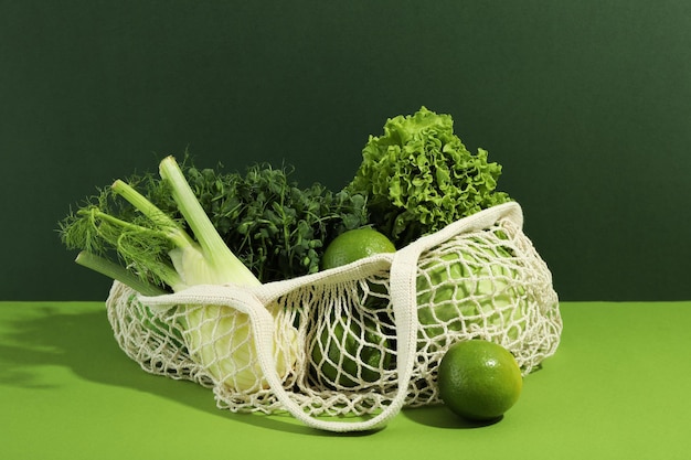 Sac à cordes avec légumes et fruits sur fond bicolore