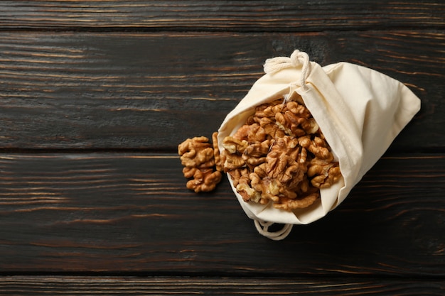 Sac en coton avec de savoureuses noix sur fond de bois