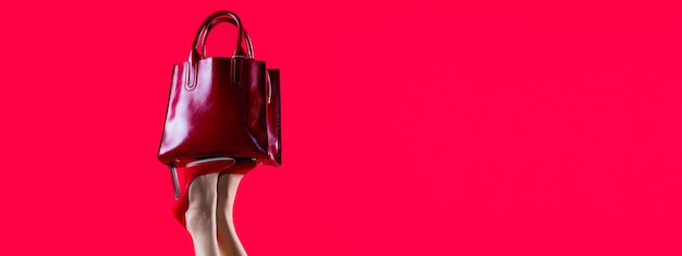 Sac en cuir femme rouge élégant Jambes féminines parfaites portant des talons hauts Jambes galbées une fille dans des chaussures à talons hauts Sac en cuir femme brillant rouge