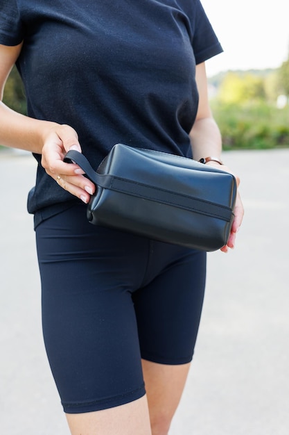 Sac en cuir noir en cuir authentique dans les mains féminines Produits en cuir