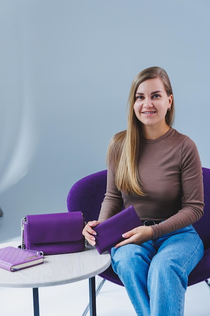 Un sac en cuir violet dans la main d'une fille