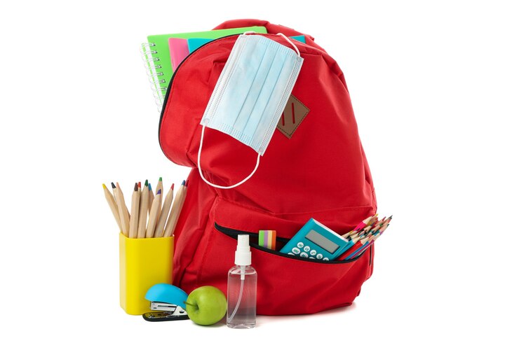 Photo sac à dos avec accessoires scolaires et masque médical isolé sur blanc